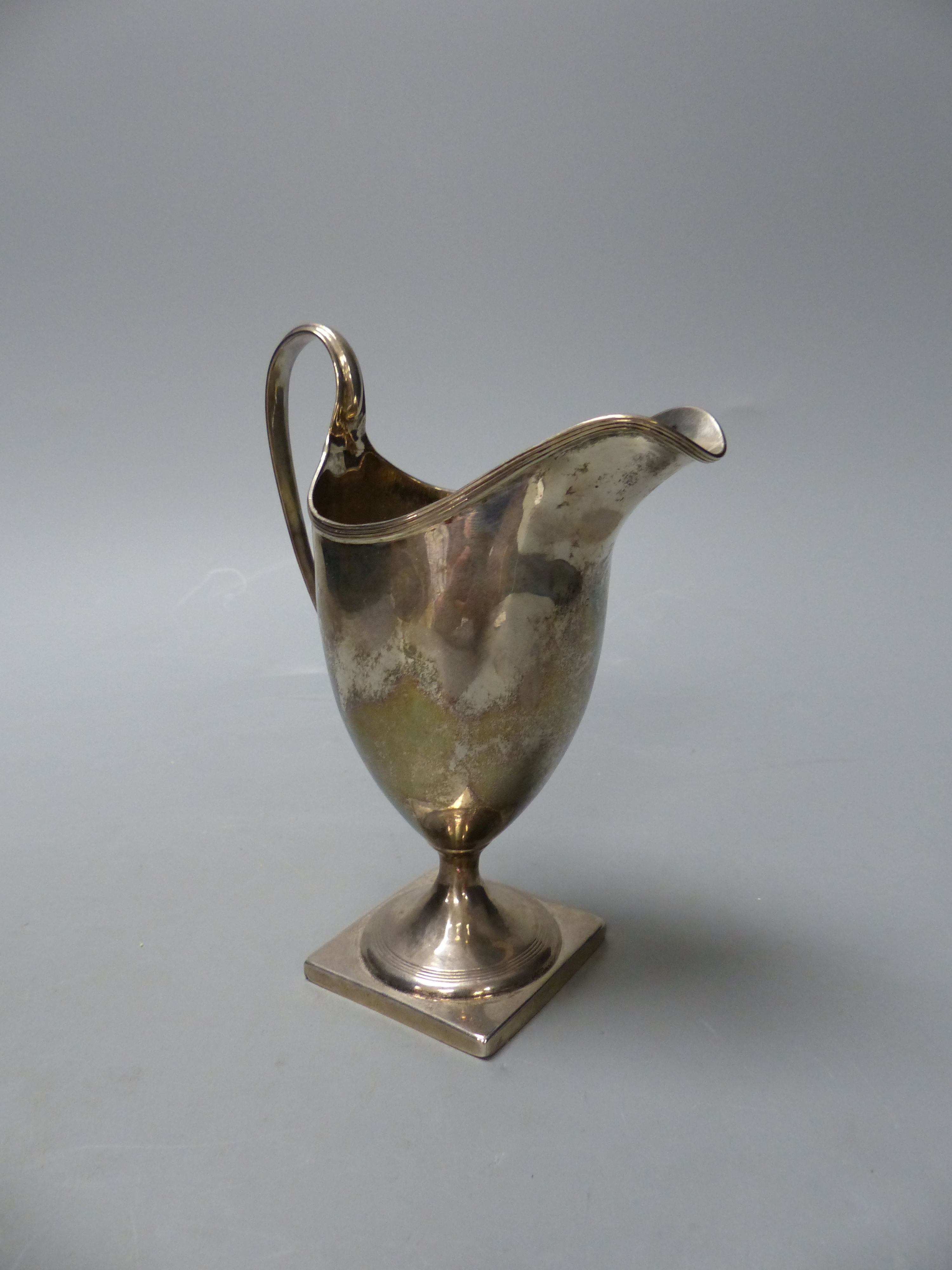 A George III silver helmet shaped cream jug, I.B, London, 1800, 14.9cm